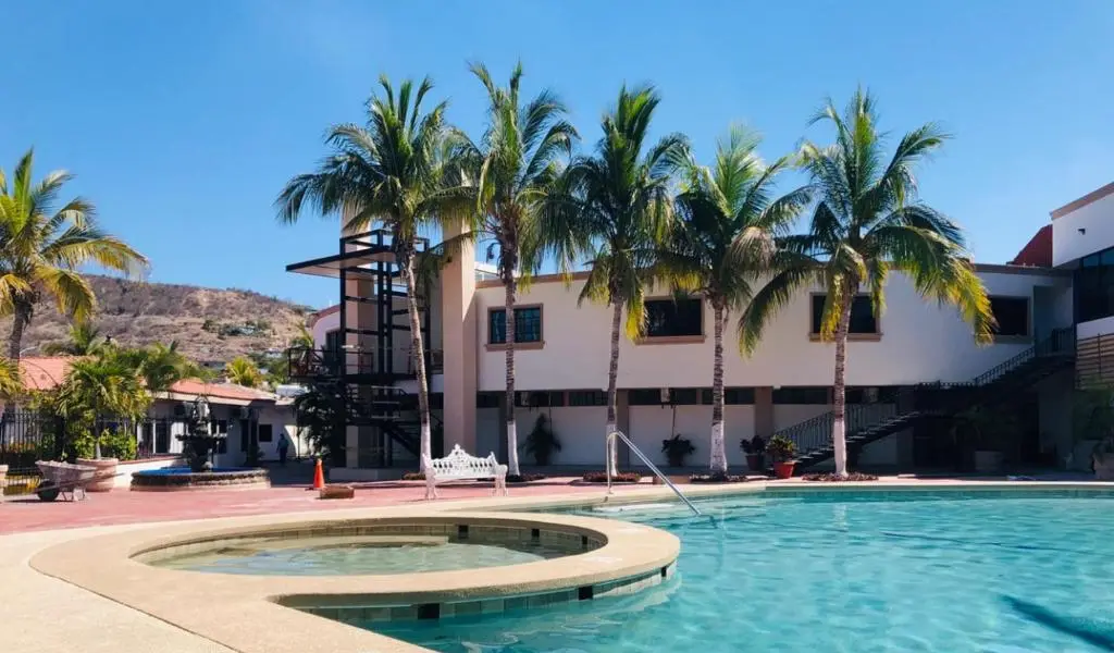 Outdoor pool and palm trees at Hotel Marina Topolobampo
